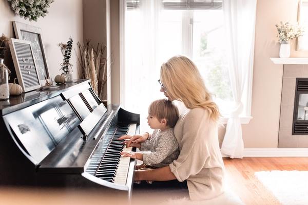 Mom teaching her kid to play piano